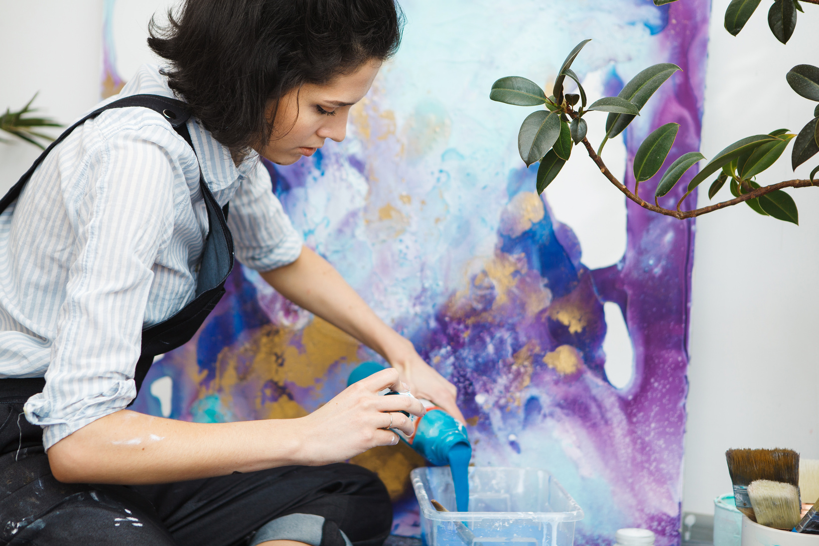 Girl pouring paint into container, going to start arts therapy